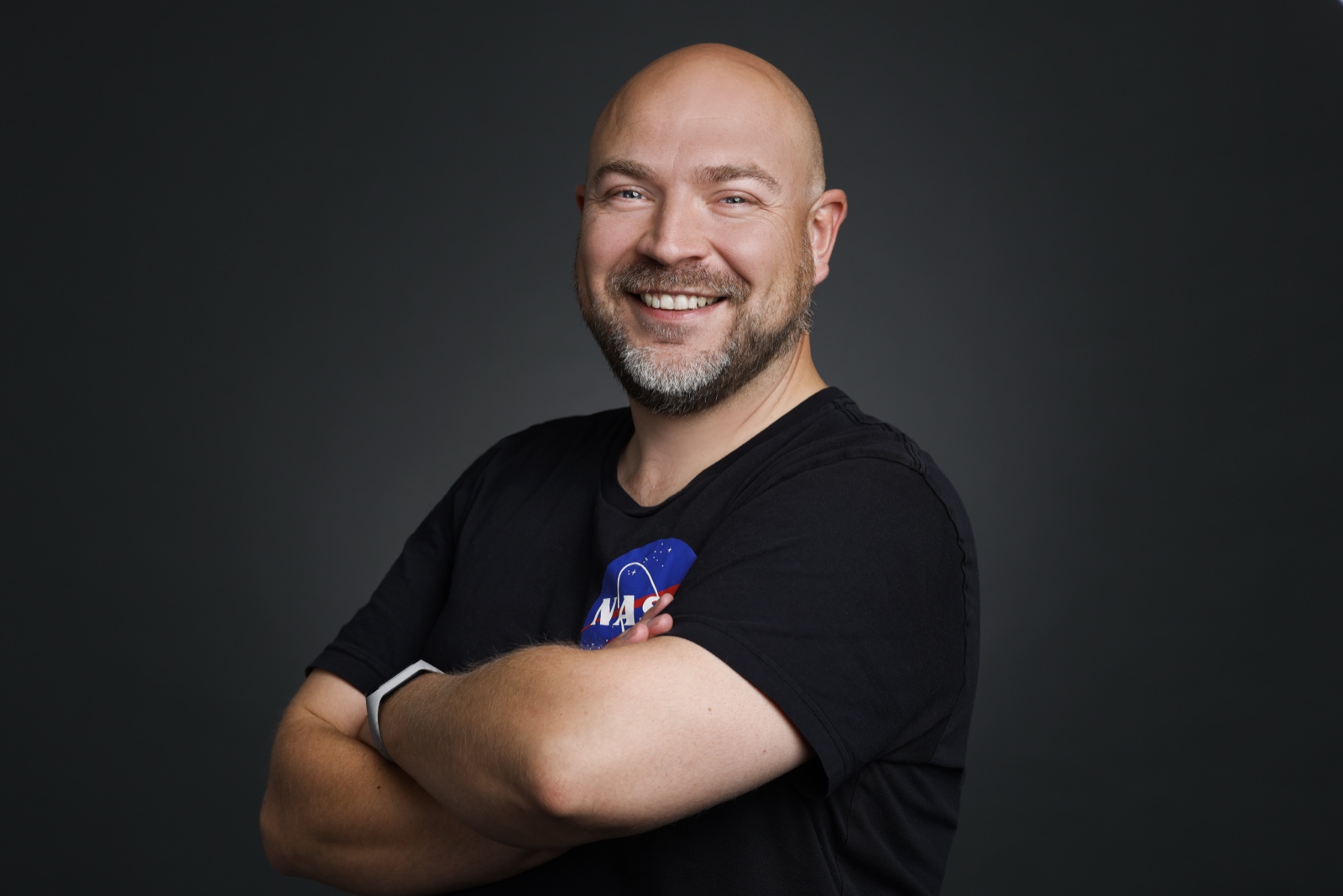 Portrait von Roman Allenstein – lächelnd, mit verschränkten Armen